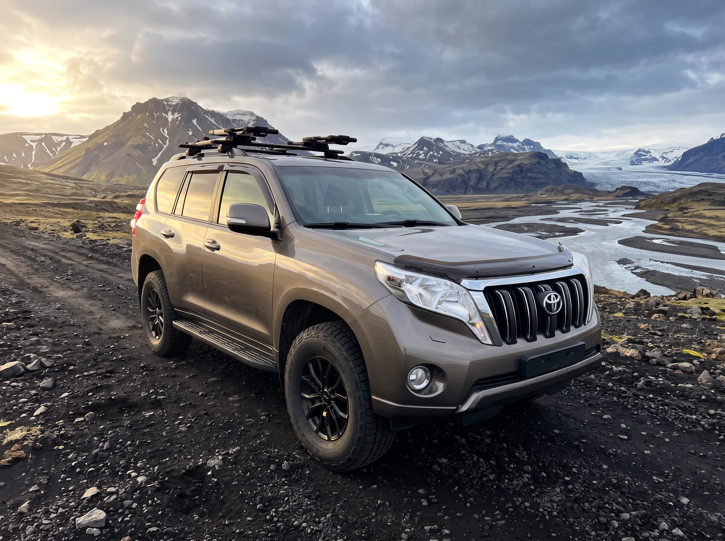 Bronze Toyota Land Cruiser GX jeep on a black volcanic track with snow-capped Icelandic mountains and a glacier behind